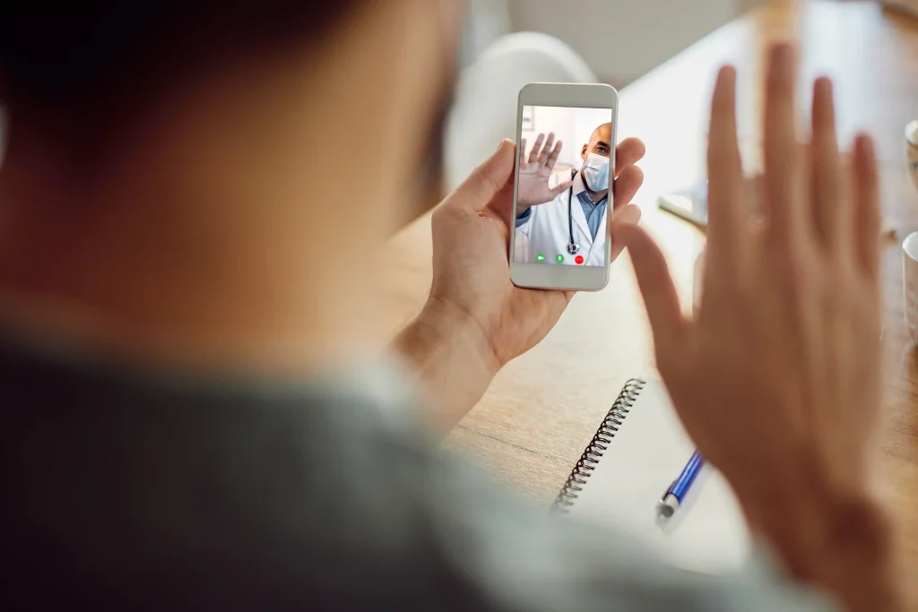 closeup african american doctor greeting his patient video call mobile phone copiar